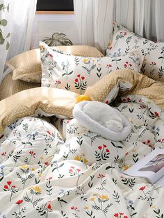 an unmade bed with flowers and polka dots