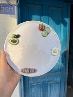 a person holding a plate with food on it in front of a blue door,