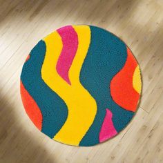 a colorful round rug on the floor in a room with wooden floors and hard wood floors