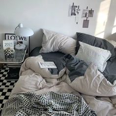 an unmade bed with black and white sheets