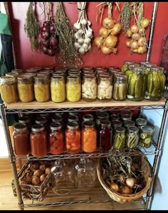 several shelves filled with different types of pickles and other food in jars on top of metal racks