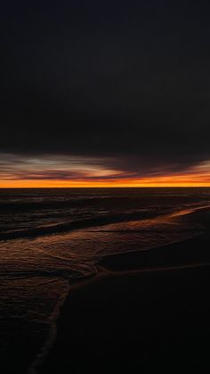 an orange and black sunset over the ocean