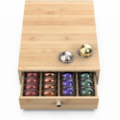 a wooden box with six different colored balls in it and two metal knobs on the lid