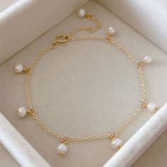 "* DETAILS * This bracelet is adjustable from 6.5\" to 8\" - Freshwater Pearls Size 3-4mm - 14K Gold Filled Chain - 14K Gold Filled Spring Ring Clasp - 14K Gold Filled Link Rings ------------------------------------------------- * CARE TIPS * - Perfumes: Be sure any perfume or lotions are completely absorbed into skin. - Hair products: Apply all hair products before putting on jewelry. - Swimming: Remove all jewelry before swimming or getting into hot tubes. - No sunlight: Store away from heat, Stylish Gold Bracelet For Women, Adjustable Gold Bracelet With Pearl Charm As Gift, Dainty White Dangle Bracelets, Adjustable Dangle Bracelets For Anniversary, Adjustable Charm Bracelets For Anniversary, Bracelet En Cuir Diy, Pearl Gold Bracelet, Bracelet With Pearls, Diy Leather Bracelet