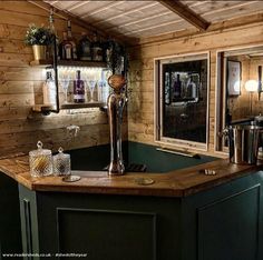 a kitchen with wooden walls and green counter tops, along with shelves on the wall