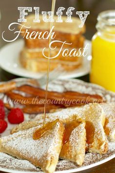 french toast with powdered sugar and strawberries on a plate next to honey syrup