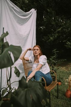 A red headed girl sitting in a chair for a backyard photoshoot with a bed sheet as the backdrop. Backyard Portrait Ideas, Home Garden Photoshoot Ideas, Hanging Sheets Photoshoot, Yard Photoshoot Ideas, Bed Sheet Backdrop Photography, Bed Sheets Photoshoot, Porch Photoshoot Picture Ideas, Sheet Background Photoshoot, Outdoor Sheet Photoshoot