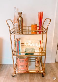 a gold bar cart with drinks on it