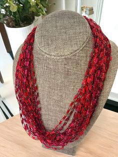 ⭐️ Stunning narrow red trellis ladder yarn scarf-style necklace. The yarn is a gorgeous red color with some burgundy accents and gold metallic thread throughout. The gold thread adds an extra bit of bling to this already shimmery yarn. This color is hard to photograph. It's a darker red than the photos would appear.  ⭐️ There is NO CLASP on this necklace at it easily fits over your head.  ⭐️ This eye-catching necklace/scarf is soft, lightweight, and very easy to wear. The yarn has an iridescent Gift Red Handwoven Beaded Necklaces, Red Handwoven Necklace For Gift, Handwoven Red Necklace, Red Handwoven Necklace, Red Multi-strand Necklace For Festive Occasions, Red Multi-strand Beaded Necklace For Festive Occasions, Festive Red Multi-strand Beaded Necklace, Ladder Yarn, Yarn Scarf