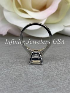 a close up of a ring with a flower in the background