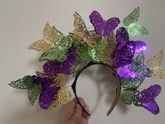 This butterfly crown is perfect for a Mardi Gras celebration and is a handmade item! Details: Handmade item Materials: 1-inch black satin headband, metallic, coated paper butterflies, adjustable wiring, (optional soft, foam roses) Can be personalized Made to Order: Pick from two different sizes; either 18 or more butterflies (pictured) or 32+ butterflies. Description: This band features front and back-facing butterflies for a more voluminous look. Your headband will be fashioned with adjustable Adjustable Headband For Carnival Festival, Adjustable Headband For Carnival, Adjustable Carnival Headband, Adjustable Purple Headband As A Gift, Whimsical Mardi Gras Costume Headpiece, Adjustable Multicolor Headpieces For Mardi Gras, Adjustable Headband For Mardi Gras Festival, Mardi Gras Fantasy Crown Costume Headpiece, Mardi Gras Festival Headband