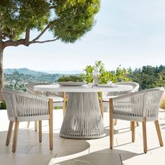 an outdoor table with four chairs around it