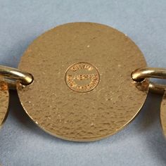 Features: - 100% Authentic CELINE PARIS. - Alternate beige enamel Celine horse carriage logo and plain gold tone medallions.. - Gold tone hardware. - Toggle closure. - Signed CELINE ABH1 Made in France. - Slip on bracelet. - Minor surface scratches. - Good vintage condition. Measurements: Height: 1.22 inches (3.1 cm) Wearable Length: 7.68 inches (19.5 cms) **This bracelet will be shipped via Priority Shipping with tracking number. Please convo me for any queries and additional photos. Thank you Vintage Jewelry With Gold-tone Logo Plaque, Formal Metal Jewelry With Logo Charm, Adjustable Gold Bracelets With Gold-tone Logo, Gold-tone Formal Bracelets With Logo Charm, Gold-tone Jewelry With Logo Charm For Formal Occasions, Formal Gold-tone Bracelets With Logo Charm, Vintage Gold Bracelet With Logo Charm, Formal Yellow Gold Bracelets With Gold-tone Logo, Gold Jewelry With Logo Charm For Collectors