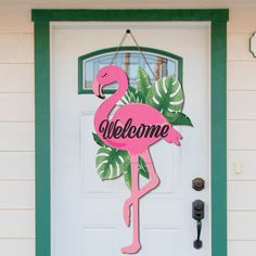 a pink flamingo welcome sign hanging from the front door