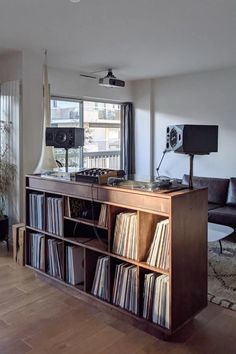 a record player is sitting on top of a wooden shelf in front of a window