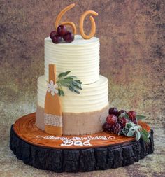 a birthday cake decorated with grapes and wine bottle on a tree stump for someone's 60th birthday