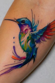 a colorful hummingbird tattoo on the leg