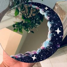 a hand holding up a mirror with stars on it