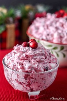 cranberry fluff salad in a bowl on a red tablecloth with two bowls behind it