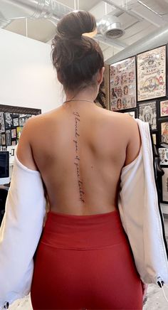 the back of a woman's body with writing on her left shoulder and right arm