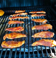 several pieces of meat cooking on an outdoor grill