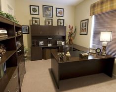 an office with two desks, shelves and pictures on the wall