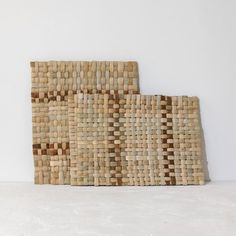 two pieces of woven material sitting on top of a white table next to each other