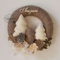 a wreath with two white christmas trees on it and the words alugr written in cursive writing