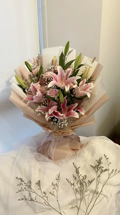 a bouquet of flowers sitting on top of a white cloth covered table next to a mirror