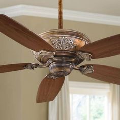 a ceiling fan with wooden blades in a room