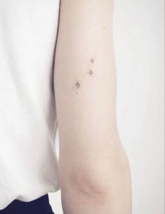 a person with a small star tattoo on their left arm and the other arm behind her