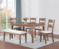 a dining room table and chairs in front of a window