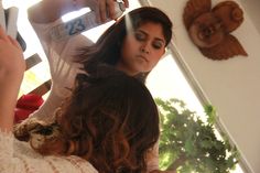 a woman getting her hair done in front of a mirror