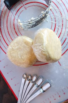 two loaves of bread sitting on top of a cutting board next to scissors and measuring tape