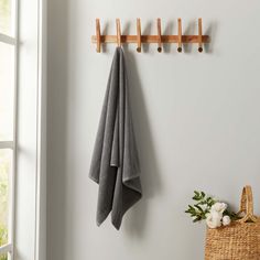 two towels hanging on the wall next to a basket with flowers and a towel rack