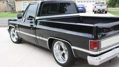 a black pickup truck parked in front of a house