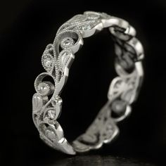 a wedding ring with intricate designs on it's sides and diamonds in the middle