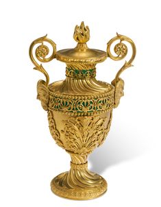 an ornately decorated gold urn on a white background