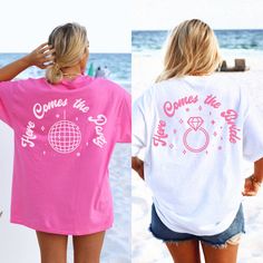 two women wearing matching shirts on the beach