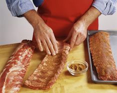 a person in an apron is cutting up some meat