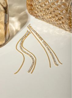 Sparkling Streamers: Dangle Earrings for Every Occasion Step into a world of timeless elegance where delicate chains adorned with sparkling rhinestones and cascading down to a radiant teardrop crystal transform your everyday into a fashion runway. These exquisite earrings, crafted from high-quality, 18K gold-plated stainless steel, are the epitome of grace and sophistication. Embrace the allure of Sparkling Streamers, a name that perfectly captures the essence of these captivating earrings.Envis Crystal Long Drop Chandelier Earrings, Long Drop Crystal Chandelier Earrings, Crystal Linear Long Drop Earrings For Party, Crystal Long Drop Linear Earrings, Elegant Chandelier Earrings With Adjustable Chain For Party, Elegant Gold Teardrop Earrings With Rhinestones, Party Long Drop Linear Earrings With Adjustable Chain, Gold Crystal Long Drop Earrings, Evening Teardrop Dangle Earrings With Rhinestones