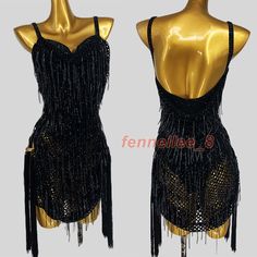 two mannequins with black and gold dresses on display in front of each other