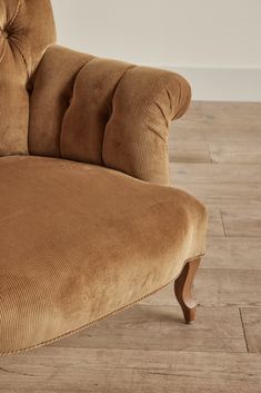 a brown couch sitting on top of a hard wood floor