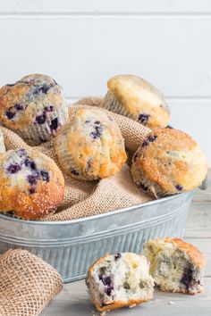 blueberry muffins in a tin on a wooden table with burlocks