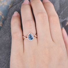 a woman's hand wearing a ring with a blue topazte and diamonds