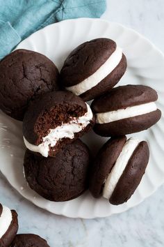 chocolate cookies with white frosting are on a plate