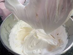 a mixing bowl filled with whipped cream on top of a counter