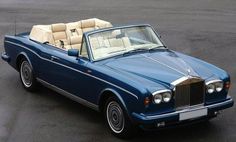 a blue convertible car parked in a parking lot