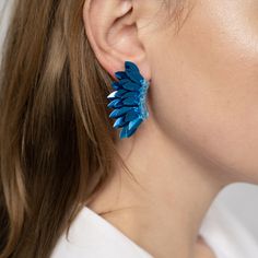 The playful Blue hue of our Royal Blue Small Wing Earrings combine whimsy and luxury for a unique look. The one-of-a-kind earrings take on the shape of angel wings with their layers of sequins arranged around a single stud. Size: Length: 2''/ Width: 1'' Light Blue Earrings For Party, Handmade Wing-shaped Jewelry For Party, Wing-shaped Earrings For Party, Angel Wings Winged Jewelry For Party, Angel Wings Jewelry For Party, Glamorous Blue Earrings For Party, Angel Wings Earrings, Small Wing, Wings Earrings