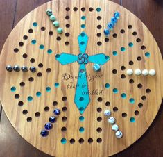 a wooden board with beads on it and a cross made out of holes in the middle